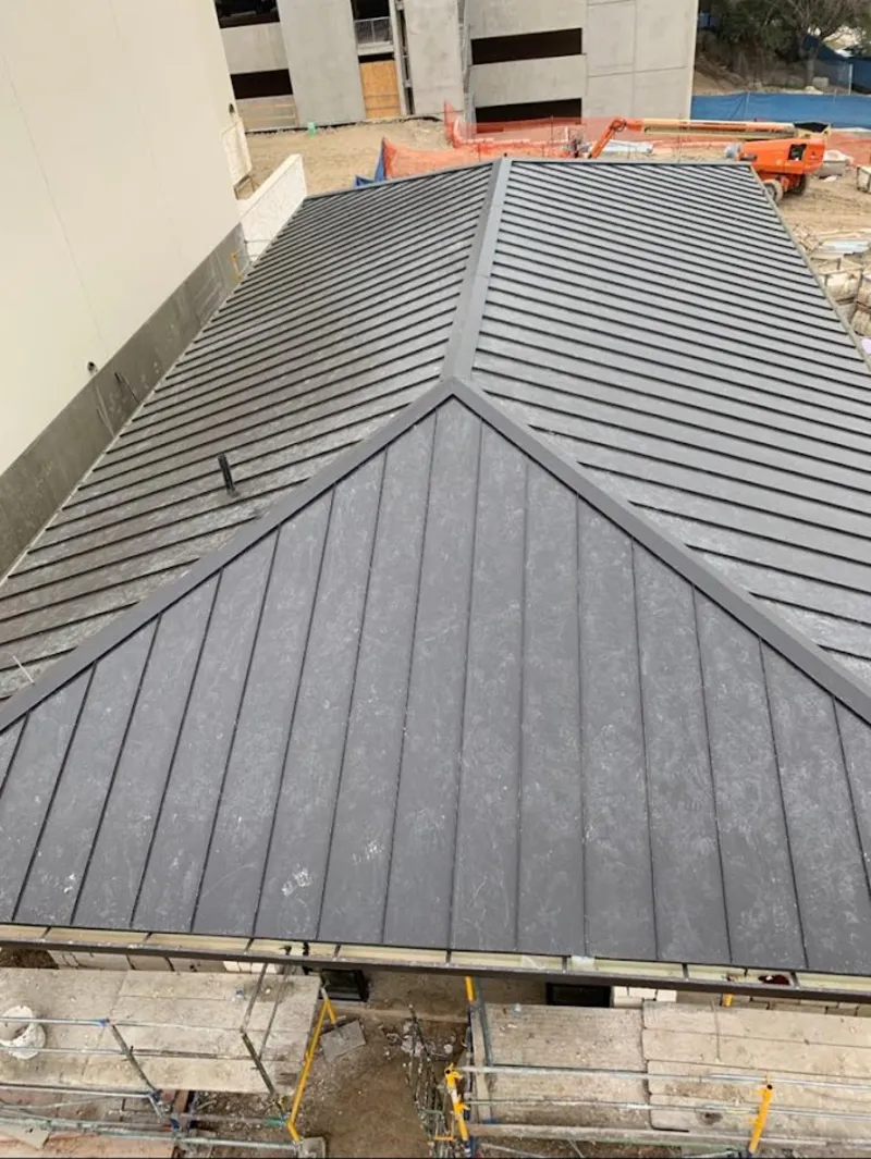 Commercial metal roof construction with crane equipment in Terrytown